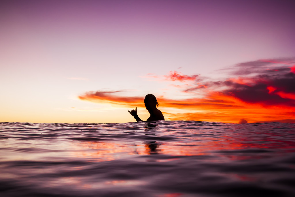 A person in the water at sunset.