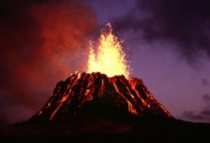 A very large volcano with smoke and fire coming out of it.