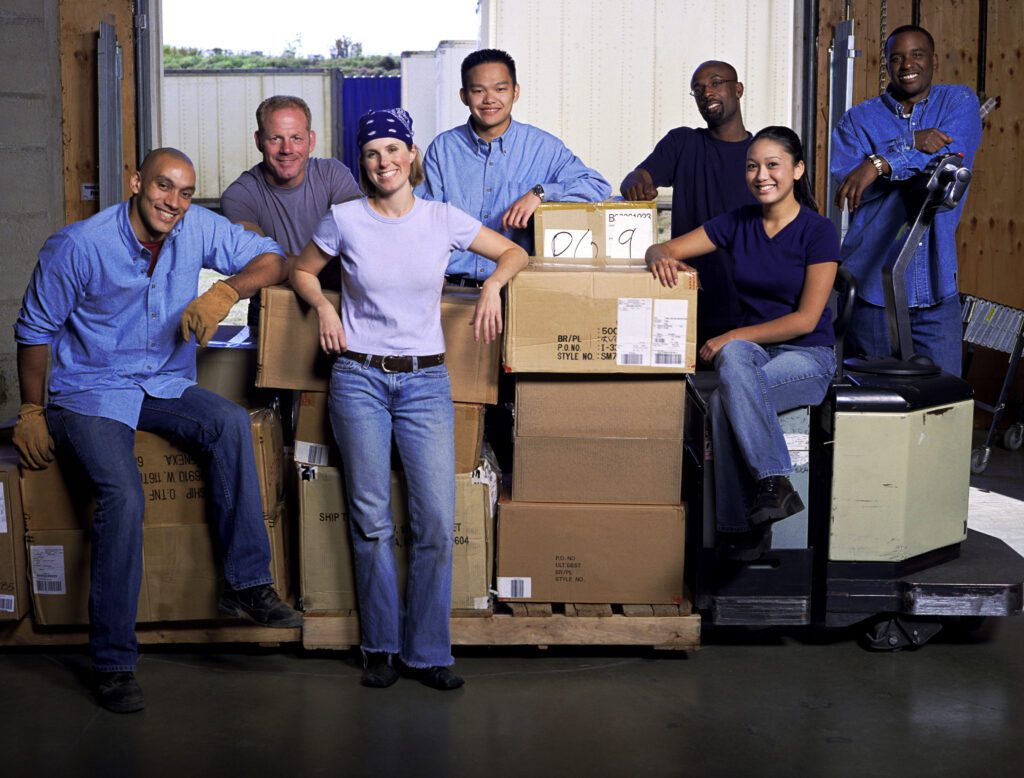 A group of people standing around boxes in a room.