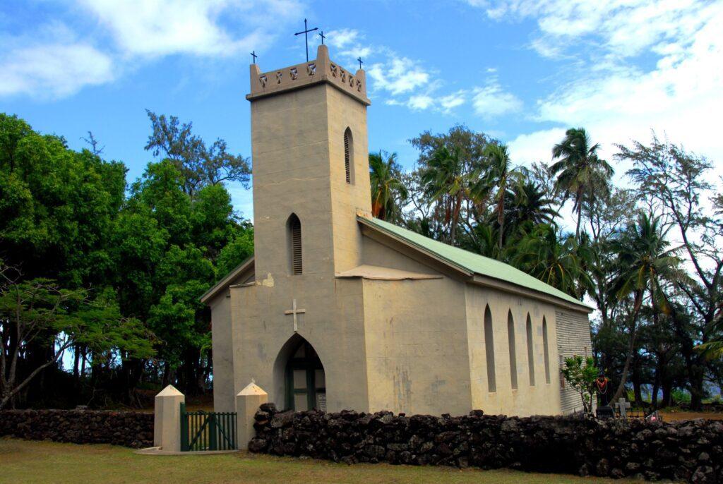 A church with a steeple and cross on top of it.