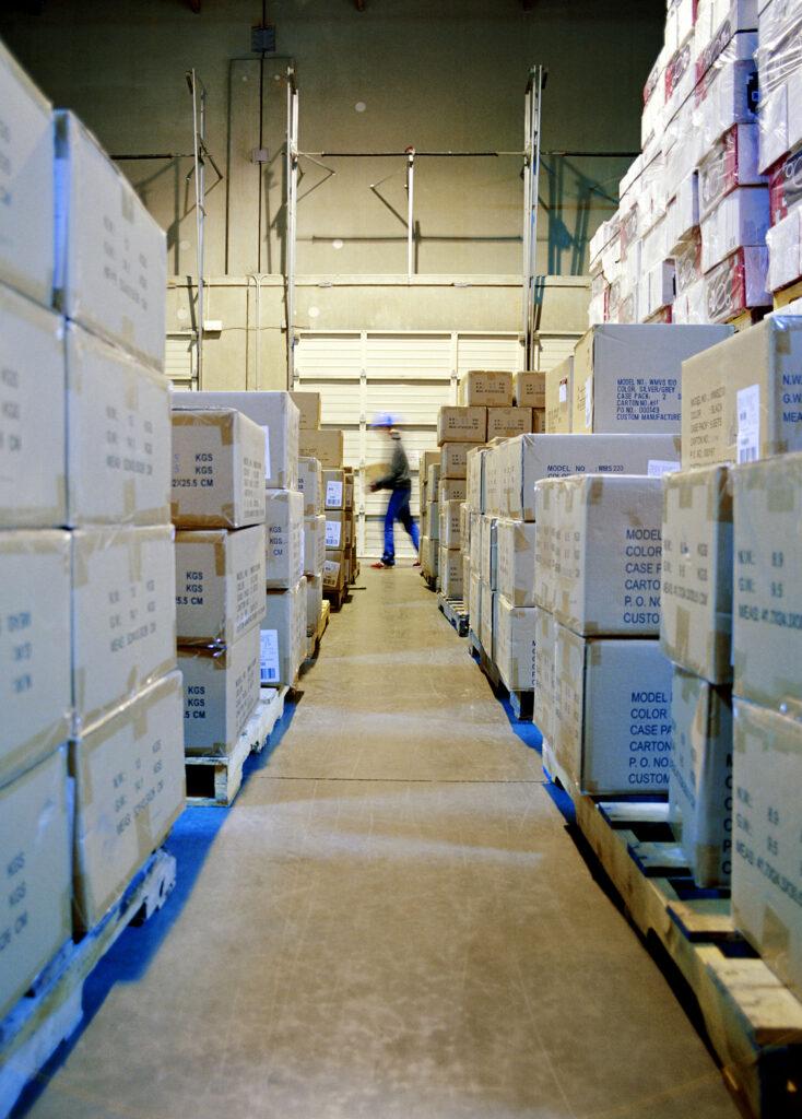 Warehouse aisle filled with stacked cardboard boxes.