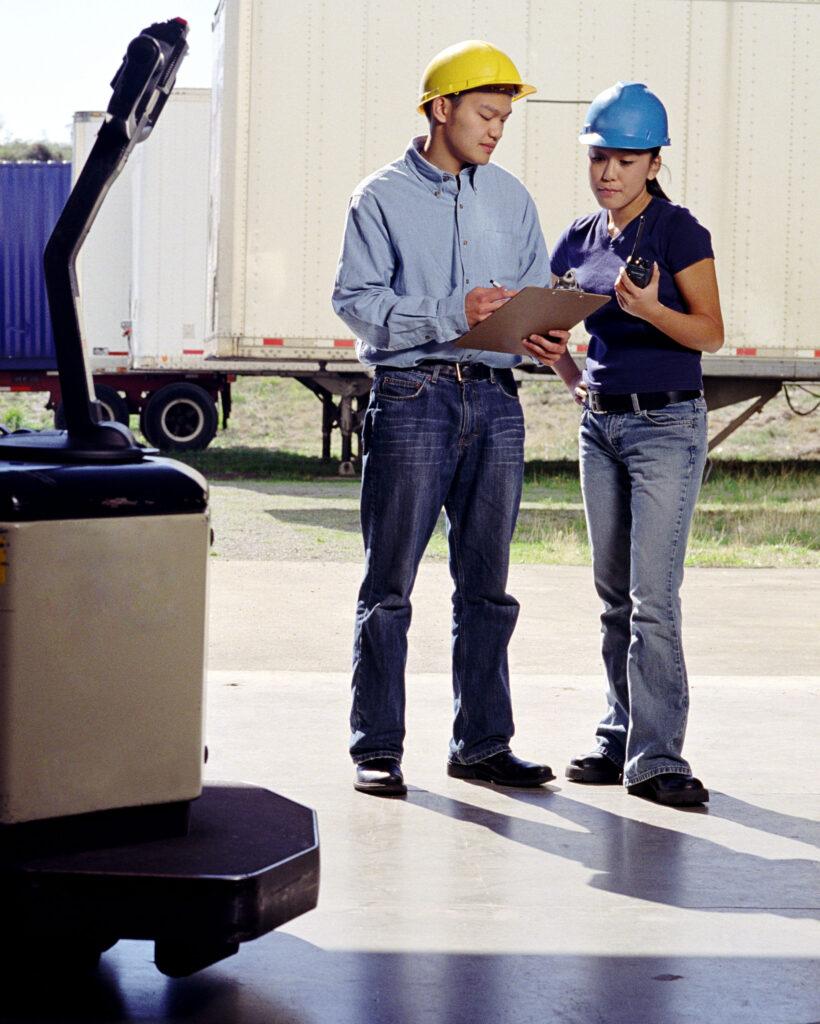 Two workers discussing on a loading dock.